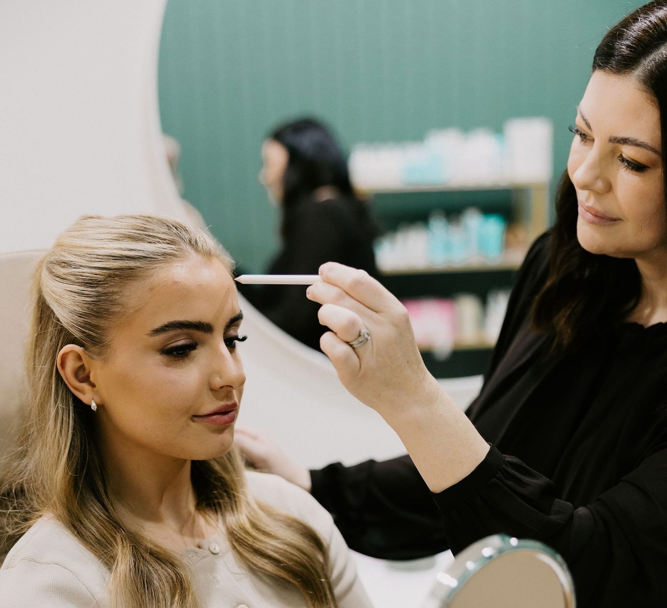 Sarah Munnings assessing a patient’s brow and forehead during a facial line consultation.