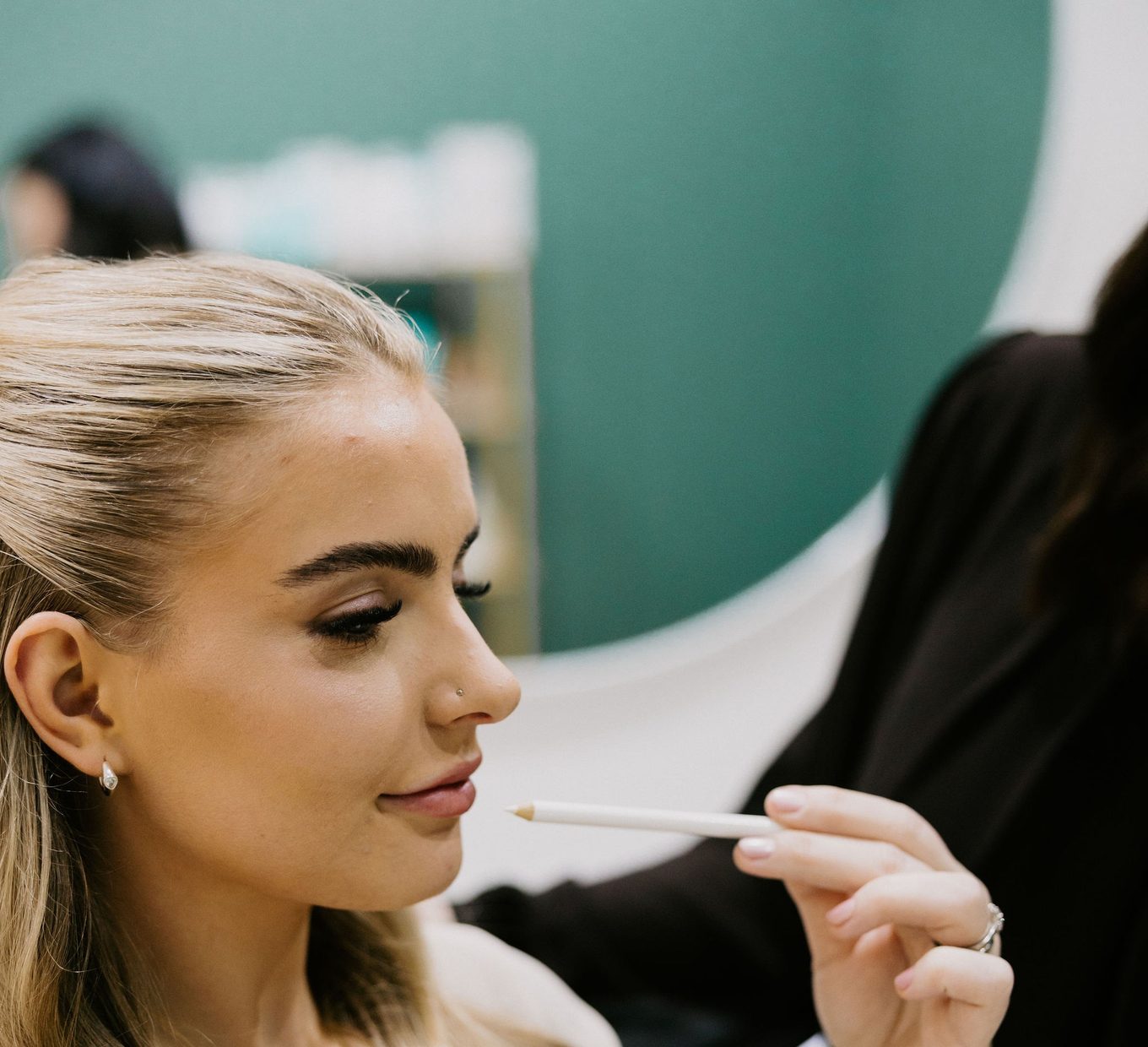 Sarah Munnings assessing a patient’s cheek and midface during a facial volume consultation.
