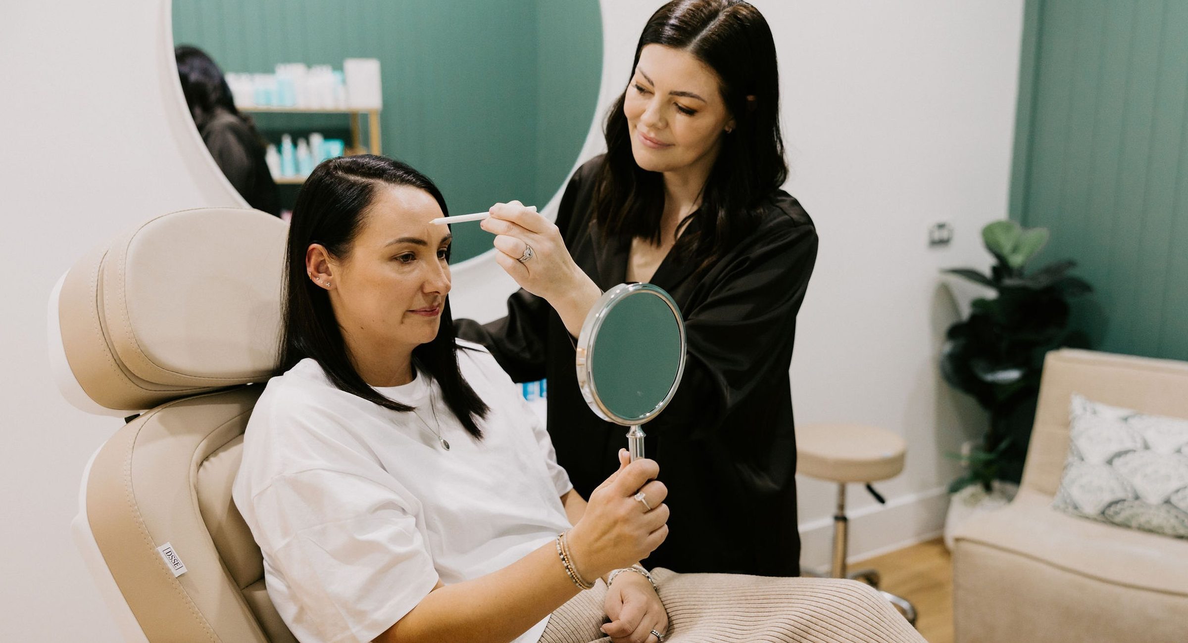 Sarah Munnings and a patient reviewing the jawline together with a hand mirror.