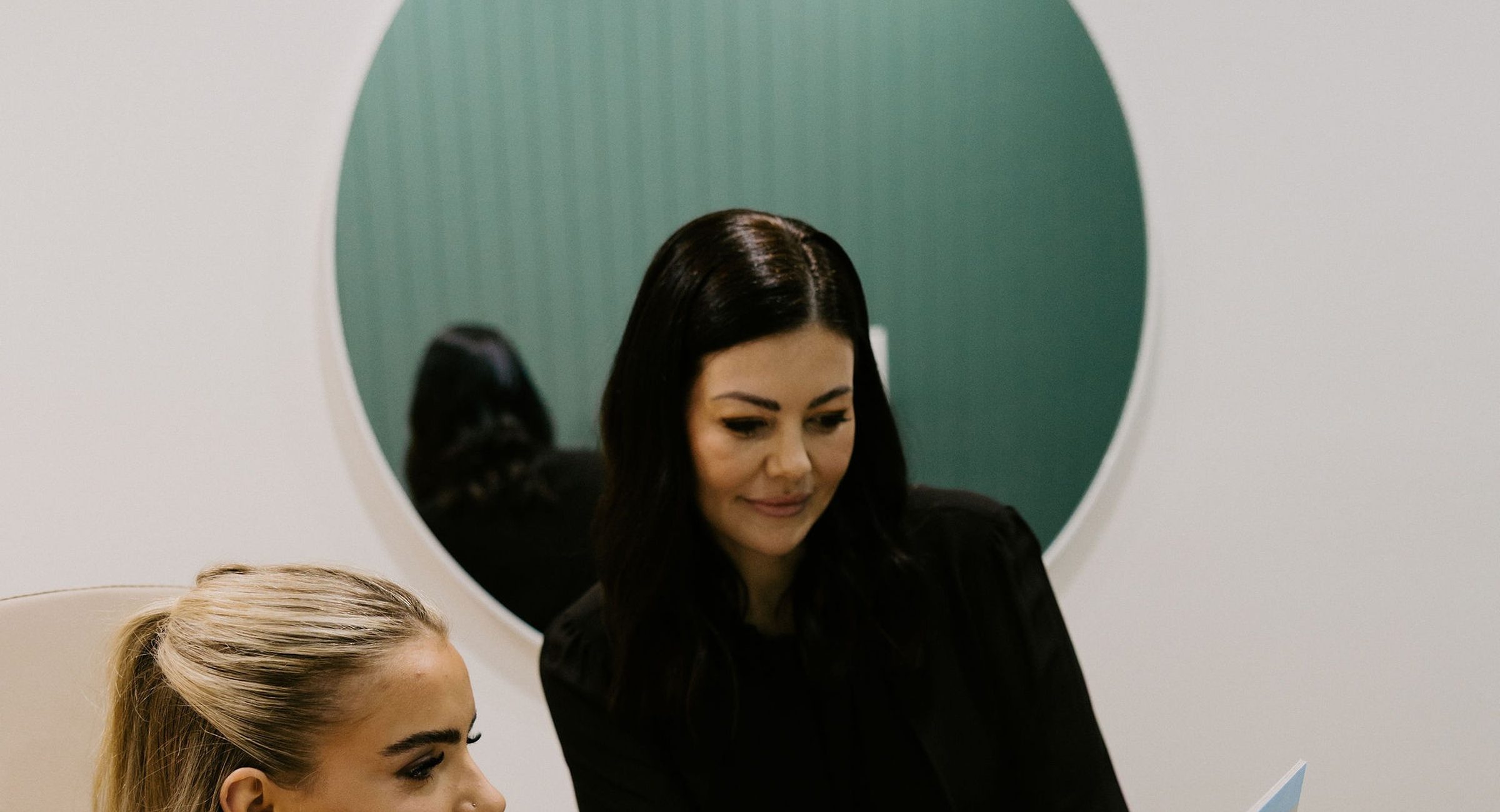 Sarah Munnings seated with a patient during a consultation at Bloom Aesthetic Clinic.