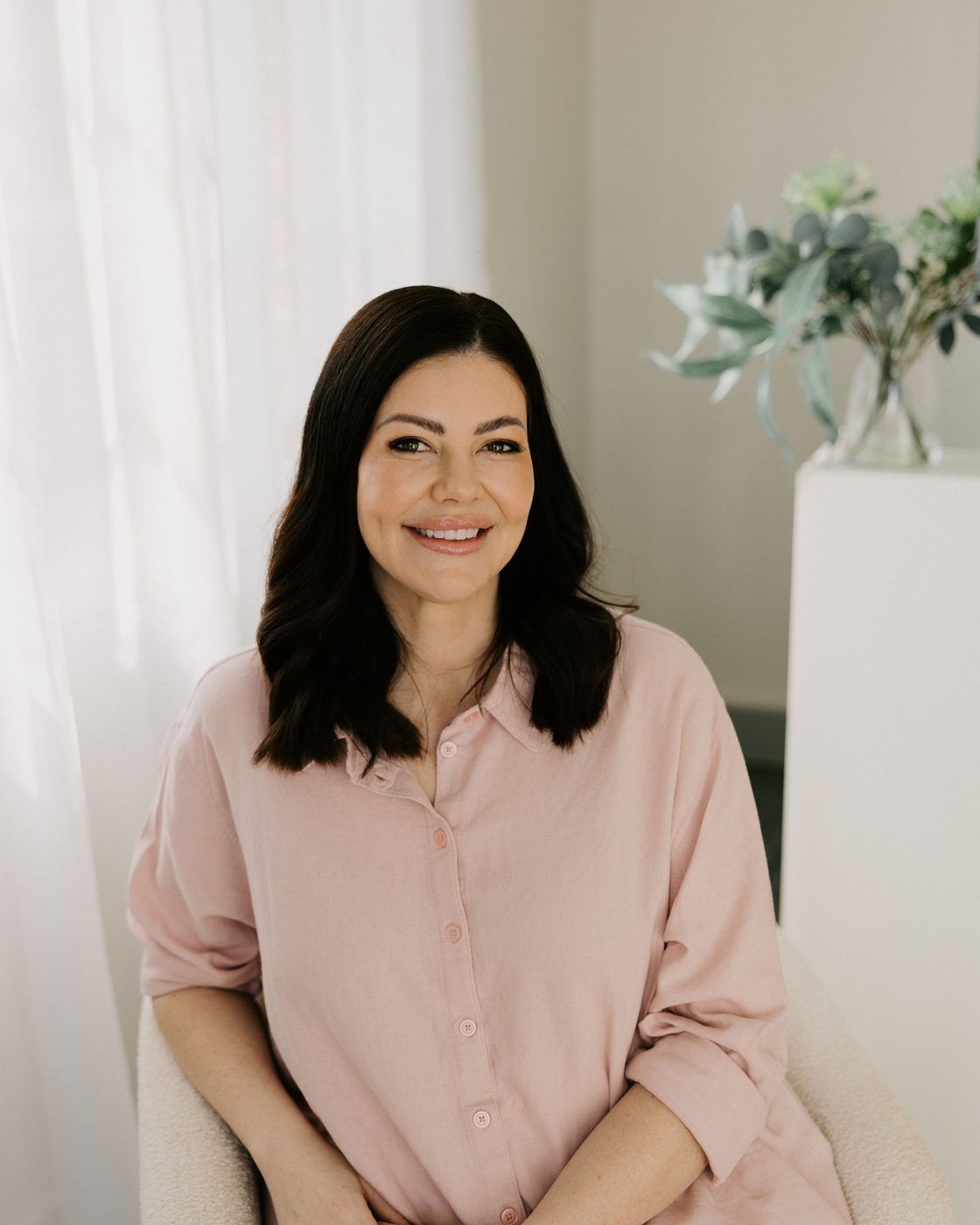 Sarah Munnings, registered nurse and founder of Bloom Aesthetic Clinic, beside a treatment chair.