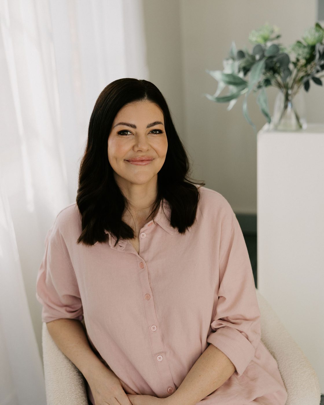 Sarah Munnings, registered nurse and founder of Bloom Aesthetic Clinic, seated in the clinic lounge.